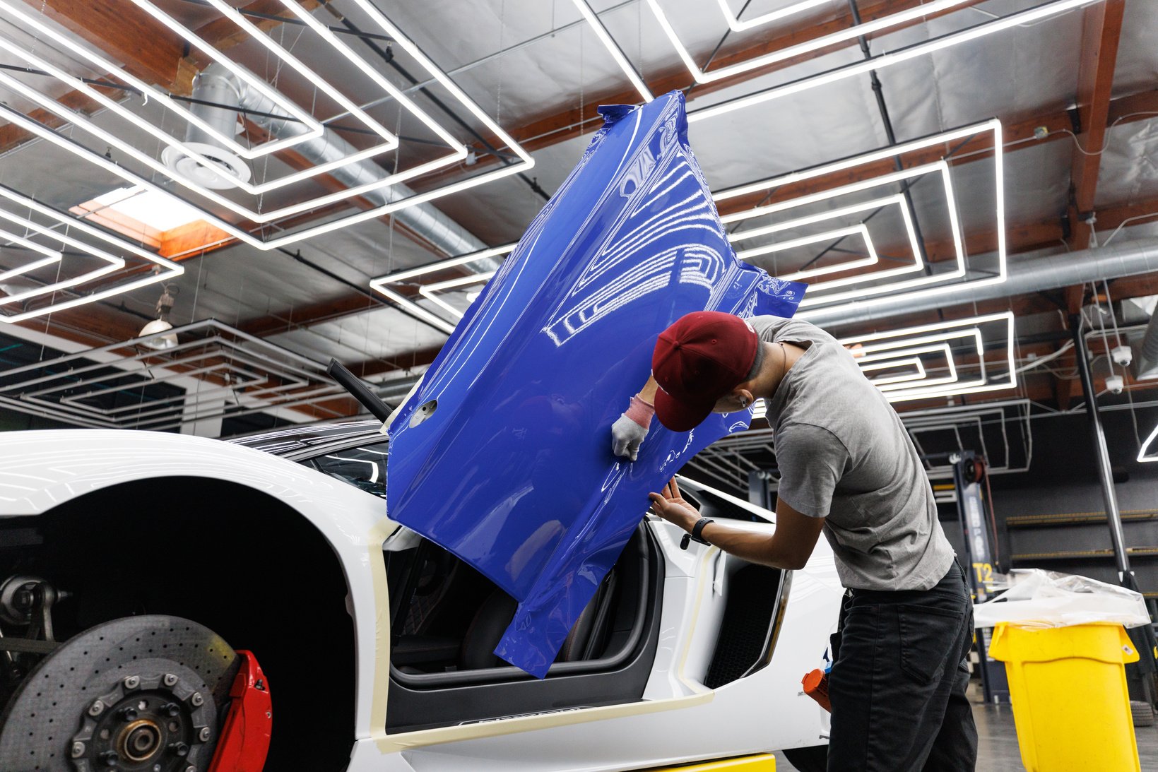 A Man Putting on a Blue Sticker on the Car Door